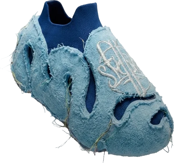 A single light blue slip-on shoe with a fuzzy outer layer, cut-outs and a white logo on top, seen at an angle.